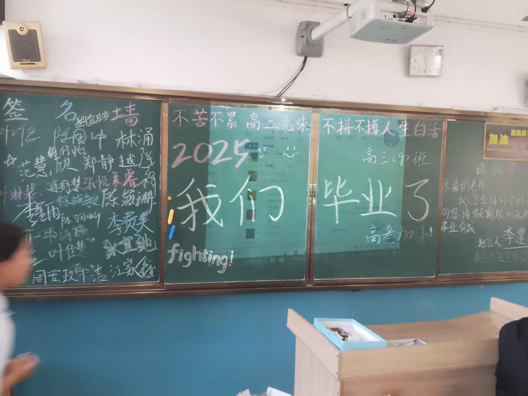 整块黑板，左边是签名墙，中间写着 2025 我们毕业了